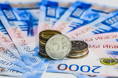 Russian banknotes and coins. A handful of coins on new Russian banknotes in denominations of 2000 and 200 rublesの写真素材