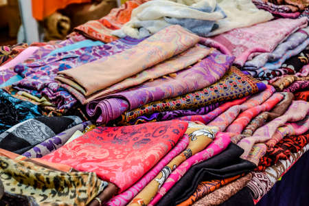 Indian fabrics folded on the counter. Trade in fabrics from india. Fabric with patterns and...