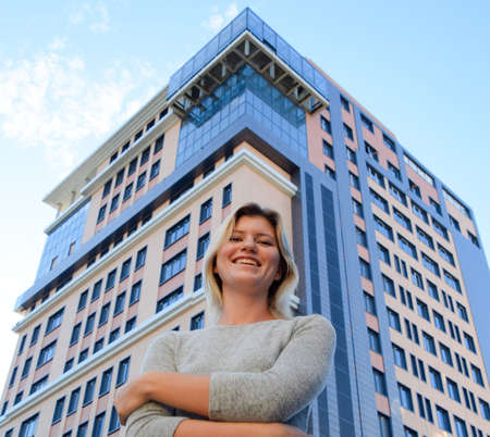 Portrait of a girl on the background of a multi-storey building. A girl with a beautiful figure in a...