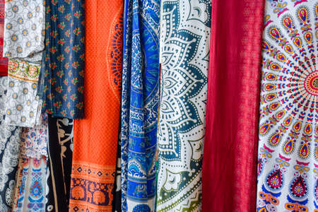 Indian fabrics hanging on the counter. Trade in fabrics from india. Fabric with patterns and patterns.の写真素材