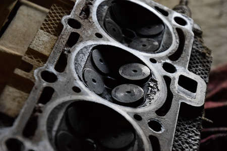 Valve in a deposit on the removed cover of the engine valve box. Engine repair. Imprint of the thread of the bolt that fell into the engine cylinder.の写真素材