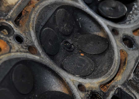 Valve in a deposit on the removed cover of the engine valve box. Engine repair. Imprint of the thread of the bolt that fell into the engine cylinder.の写真素材