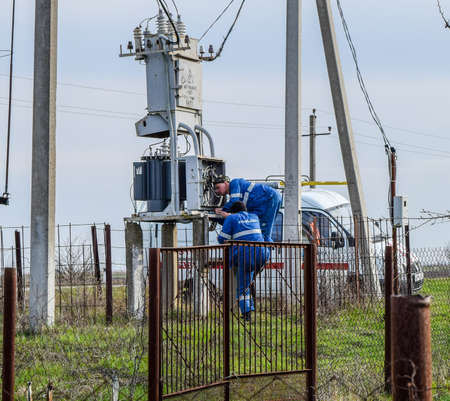 Krasnodar, Russia - March 23, 2018: Electricians repair electrical transformer. Repair team on the...
