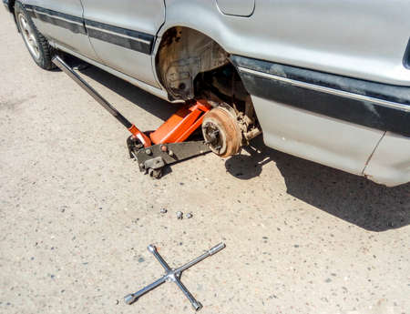 The car is at the tire shop. Under the jack the car in car-care center. The car with the removed wheelの写真素材