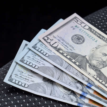 Several banknotes American dollars lie on the car seat. The money in the car.の写真素材