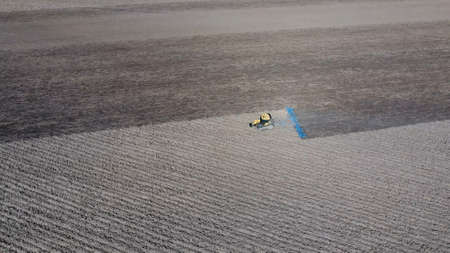 The tractor harrows the soil on the field for sowing. Spring soil cultivation