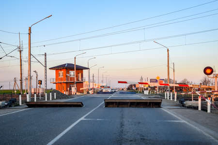 Krasnodar, Russia - March 31, 2018: Railroad crossing with a barrier and a traffic light.