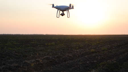 drone silhouette against the background of the sunset. Flying drones in the evening sky.