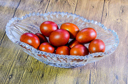Painted Easter eggs in a crystal vase. Red painted chicken eggs for easter.
