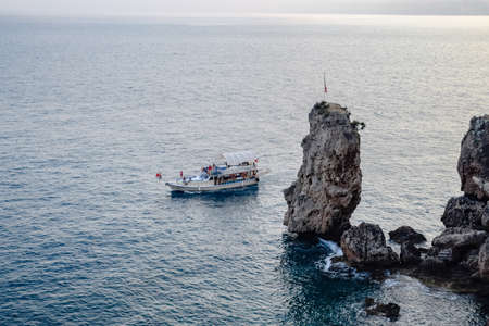 Antalya, Turkey - May 19, 2019: The yacht sails along the rocky coast, an excursion along the coast...