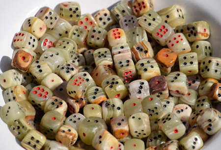 Dice made of green stone. Bowl with dices.