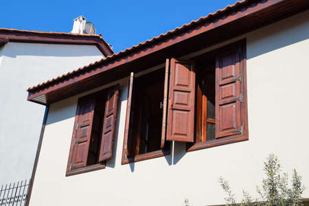 Ancient house with wooden shutters on the windows. City Kaleici in Turkey.