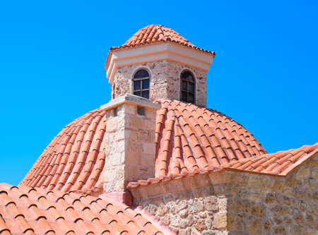 Tiled roofs, blue sky. Mosque in the distanceの写真素材