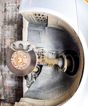 The car is a hundred for repairs. The wheel is removed. Replacement of shock absorber.の写真素材