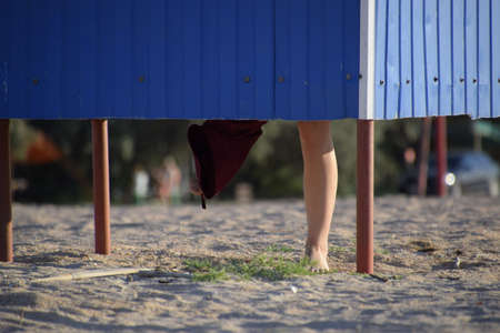 Dressing room on the beach, girl's legs are visible from the dressing room, the girl changes clothes on the beachの写真素材