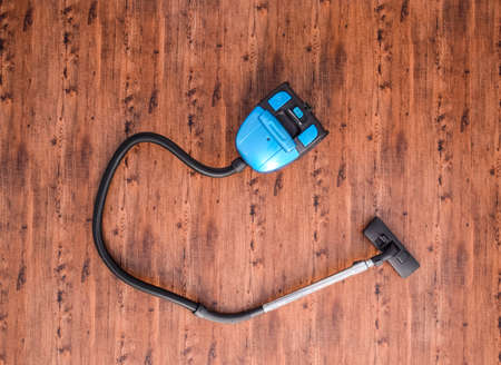 Vacuum cleaner on the floor in the room, top view.の写真素材