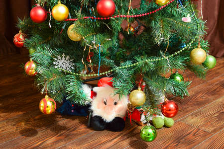 Christmas toys and ornaments on the Christmas tree. Tinsel, balls and toys decorated fir.の写真素材