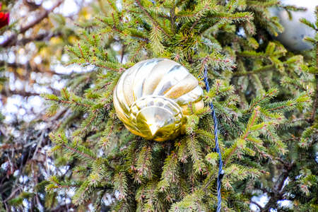Tinsel and toys, balls and other decorations on the Christmas Christmas tree standing in the open...
