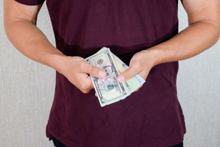A man holds a wad of dollars in his hands. US Dollarsの写真素材