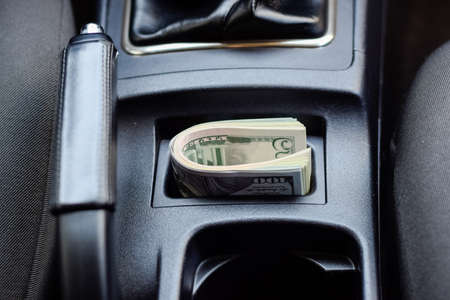 A wad of dollars inside the car. A wad of dollars inside the car.の写真素材