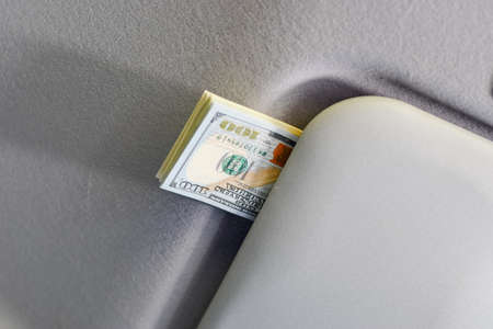 Money under the sun visor inside the car. dollars in the car.の写真素材