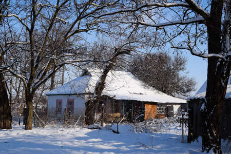 Village house in a Russian village in winter. The house is in the snow.の写真素材