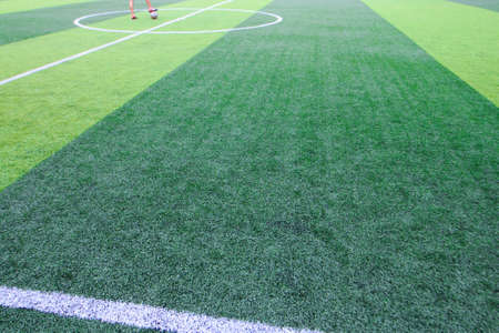 Photo of a green synthetic grass sports field with white line shot from aboveの写真素材