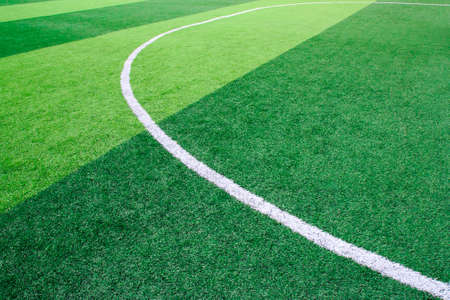 Photo of a green synthetic grass sports field with white line shot from aboveの写真素材