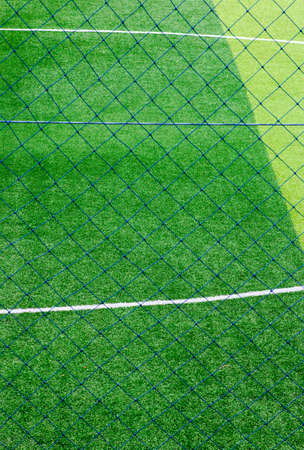 Photo of a green synthetic grass sports field with white line shot from aboveの写真素材