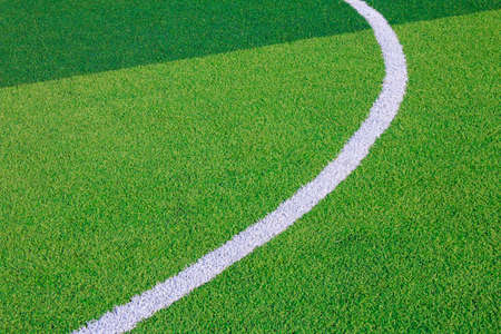 Photo of a green synthetic grass sports field with white line shot from above.の写真素材