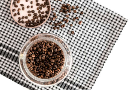 Composition photo with coffee beans in a glass jar on a kitchen towel. Photo with copy space.の写真素材