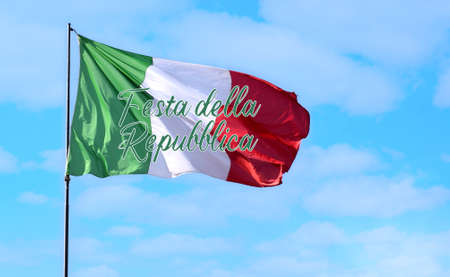 Italian flag flying in a blue light sky. Italian fly with the text: Festa della Repubblica. Photo relate to a National public holiday in Italy. Real flag. Photo with copy space.の写真素材