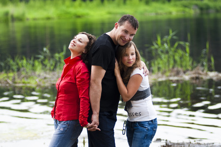 Portrait of parents with teenager daughter relaxing on natureの写真素材