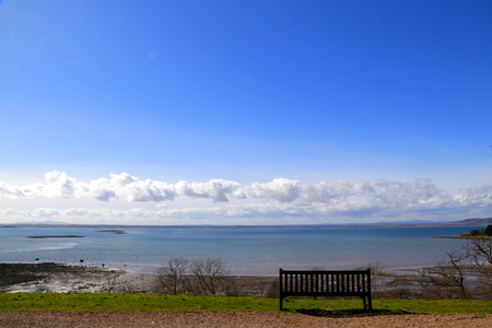 Bench on a spring day in Ireland with a view of the seaの写真素材