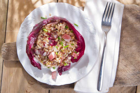 Presentation of brown rice with bacon and red radicchioの写真素材