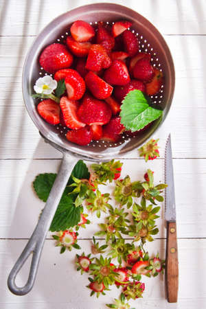 Preparing a fruit salad, strawberries into small pieces. の写真素材