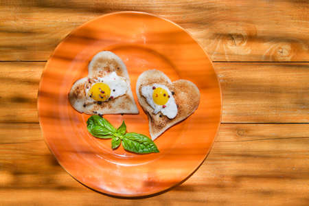 breakfast of toast and eggs in the shape of heart の写真素材