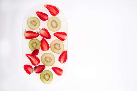 Series of slices of kiwi fruit and frozen strawberriesの写真素材