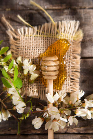 Presentation of small wooden spoon with acacia honey with its flowerの写真素材