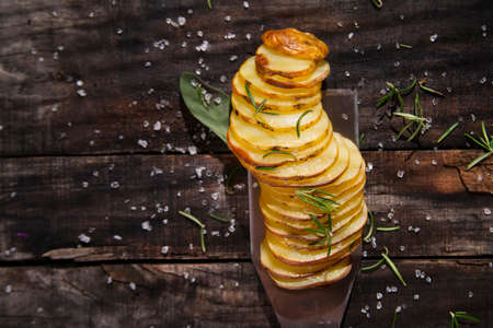 Presentation of slices of potato cooked in the oven with herbsの写真素材
