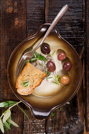 Snack of homemade bread and black olives in brineの写真素材
