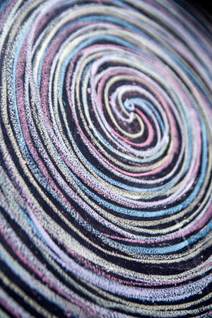Spirals of different colors drawn with chalk on blackboardの写真素材