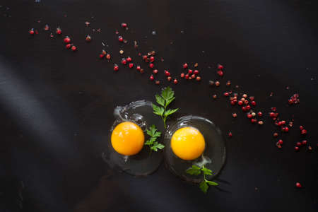 Presentation of fresh and raw eggs on the black floor of pumiceの写真素材