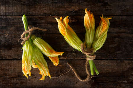 Presentation of fresh yellow pumpkin flower on wooden backgroundの写真素材