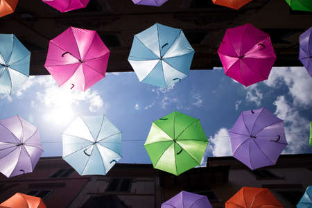 A series of umbrellas of different colors hung with a steel wireの写真素材