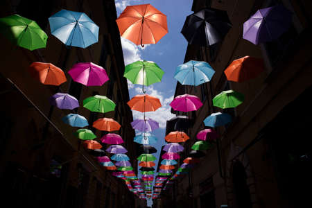 A series of umbrellas of different colors hung with a steel wireの写真素材