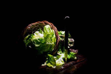 Presentation of a salad basket in a wicker basket on a black backgroundの写真素材
