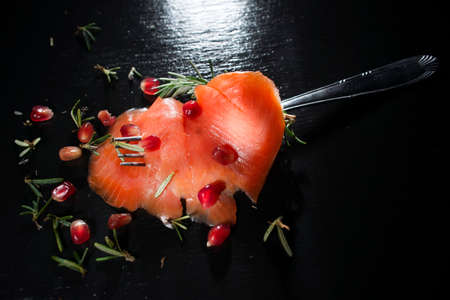 Presentation of salmon slice on black slate plateの写真素材
