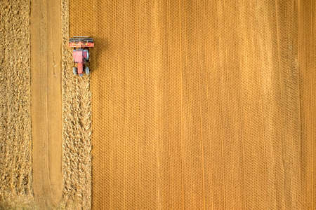 Top view with the use of a drone of the moment when a tractor plows the earthの写真素材