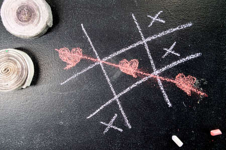 Photographic representation drawn with chalk of the game of tic-tac-toe with heart symbolsの写真素材